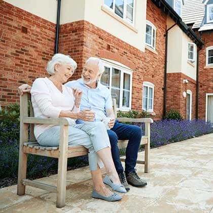 Post hospital care woman and man smiling on a bench